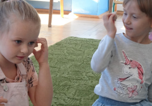 Dziewczynki przykładają muszelki do ucha